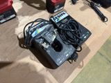 two batteries and a charger sitting on a table