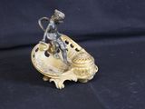 bronze figurine of a boy on a shell on a black background
