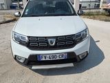 l'avant d'une Dacia blanche garée sur un parking