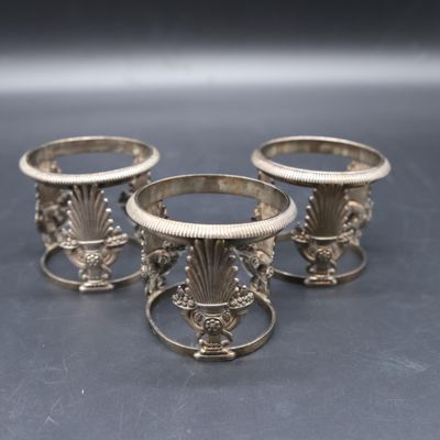 three silver vases sitting on top of a table next to each other