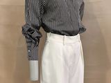 a mannequin wearing a black and white striped shirt and white pants