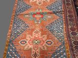 three oriental rugs on display in a room with a gray background