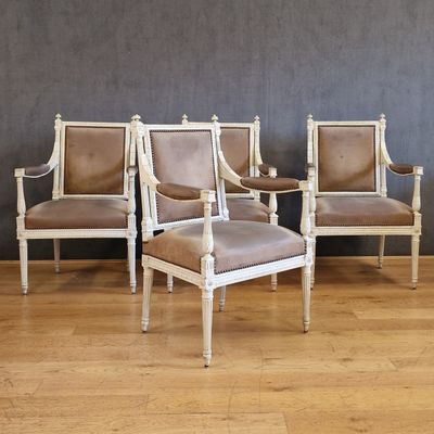 quatre chaises et une table dans une pièce avec un mur