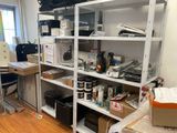 une pièce équipée d'un bureau, d'étagères, d'une chaise et d'une imprimante