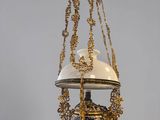 an old fashioned hanging lamp with a white and gold shade