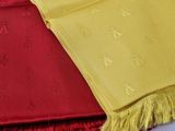 des écharpes jaunes et rouges posées sur un lit recouvert d'une couverture rouge et jaune