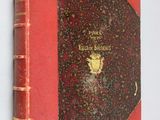 an old red book sitting on top of a white wall