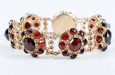 un gros plan sur un bracelet orné de pierres rouges et noires