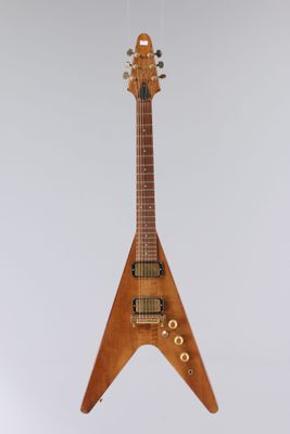 une guitare électrique suspendue à une ficelle sur un mur blanc