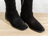 a close up of a pair of black boots on a wooden surface