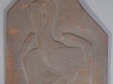 une plaque en pierre représentant une femme assise sur une chaise