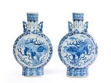 une paire de vases bleus et blancs ornés d'animaux sur un fond blanc