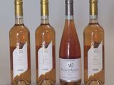 Trois bouteilles de vin rosé sont alignées sur une table
