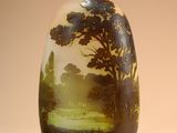 a vase with a painting on it sitting on a table
