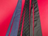 four different neck ties are lined up on a red surface