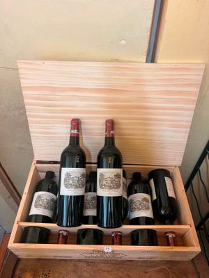 several bottles of wine are in a wooden box on a table