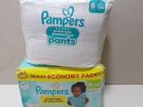 two boxes of diapers sitting on top of each other on a table