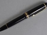 an image of a pen with a gold trim on a gray surface