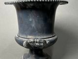 a silver vase that is sitting on a table