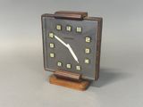 a clock that is sitting on a wooden stand
