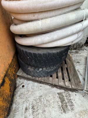 a pile of hoses stacked on top of a pile of tires