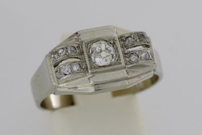 gros plan d'une bague avec des diamants sur une surface blanche