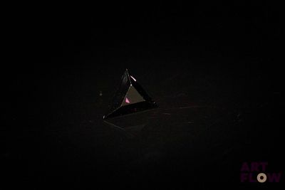 un gros plan d'un objet triangulaire dans l'obscurité