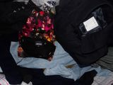 un tas de vêtements et un sac à dos posés sur un lit