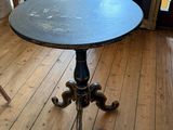 une petite table sur laquelle est posé un tableau, dans un coin de la pièce