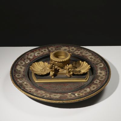 une assiette posée sur une table, sur laquelle se trouve un bougeoir