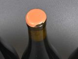 four bottles of wine are lined up in a row on a table