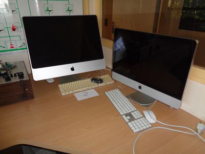 deux écrans d'ordinateur et un clavier sur un bureau