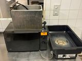 deux casseroles posées sur une table dans une cuisine équipée d'une cuisinière