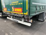 un camion vert et jaune garé sur un parking
