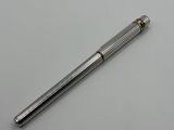 un stylo à bille argenté posé sur une table blanche