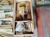 a box full of books sitting on a table next to a suitcase