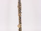 a black and gold clarinet that is sitting on a white surface