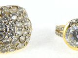 two gold rings with diamonds on a white background