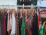 a lot of clothes hanging on a rack in a room