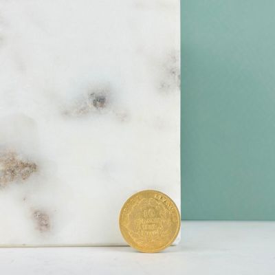une pièce d'or posée sur une dalle de marbre