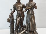 statue en bronze représentant une femme et un enfant accompagnés d'un chien, posée sur une table