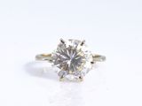 a close up of a diamond ring on a white surface