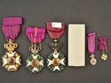 five medals and a book sit next to each other on a table