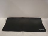 the back of a black computer mouse pad on a white surface