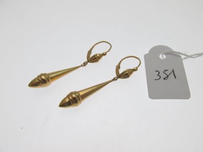 une paire de boucles d'oreilles en or avec une étiquette de prix sur fond blanc