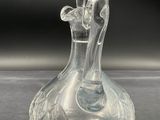 a clear glass bottle with a handle on a table