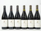 six bouteilles de vin sont alignées sur une table