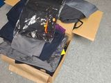 une pile de vêtements dans une boîte en carton posée sur le sol
