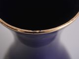 a close up of a purple vase with a gold rim