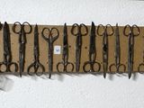 de nombreuses paires de ciseaux accrochées les unes à côté des autres sur le mur